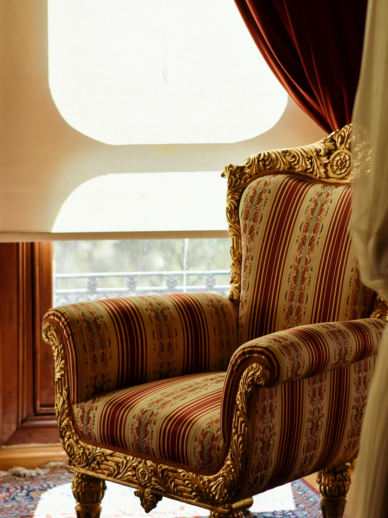Vintage ornamented armchair with carved frame and patterned upholstery