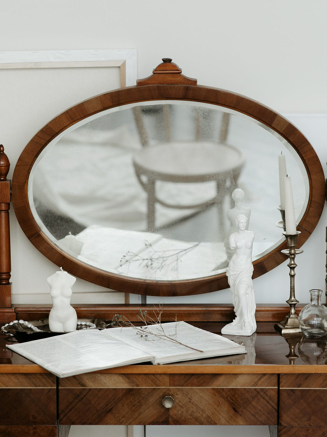 Brown wooden vanity table with an oval mirror